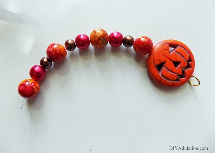 Start planning your October style now by making this pretty spooky DIY jack-o-lantern bracelet; an easy seasonal piece to rock with an everyday fall outfit!