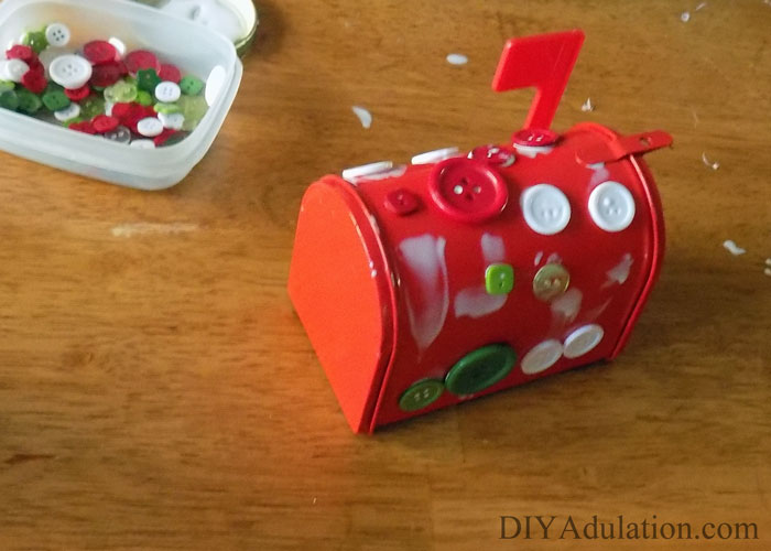 Do you love building up the excitement before Christmas? Advent calendars are a fantastic way to do this. I have also found that the small gifts that go along with advent calendars are a great way to allay kiddos anxiousness over the pretty packages under the tree. This year try something a little different with these unique DIY advent mailboxes! They are easy enough to make that a 2 year old can do it. Trust me, I have photographic proof.