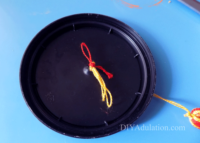 Knotted floss on underside of lid