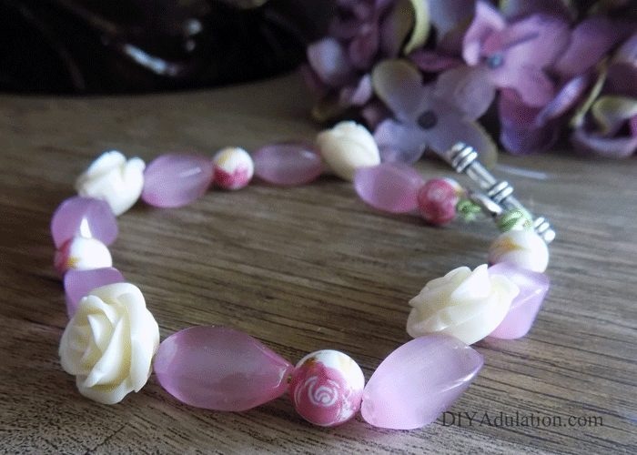 Pink floral beaded bracelet on wooden table