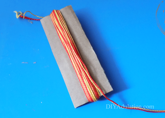 Red and yellow DMC floss wrapped around cardboard