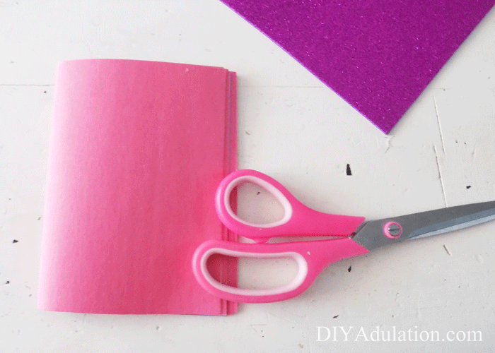Folded stack of construction paper with a pair of scissors