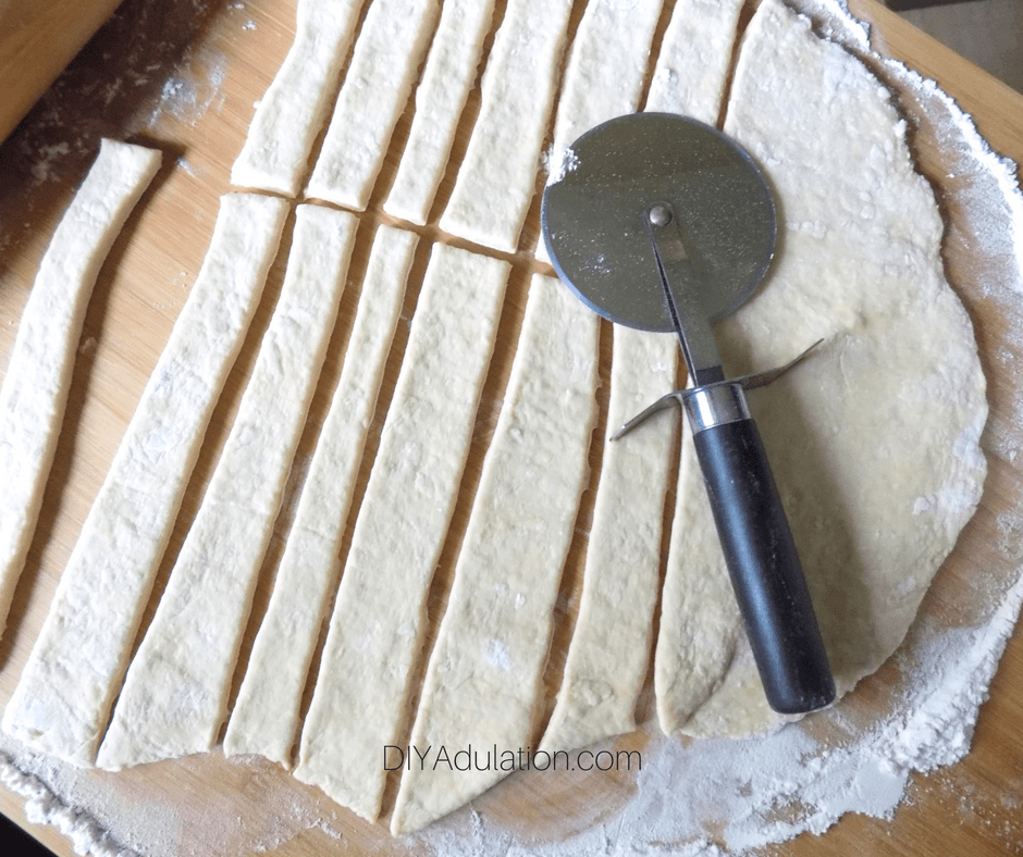 Close Up of Cut Strips of Dough with Pizza Cutter