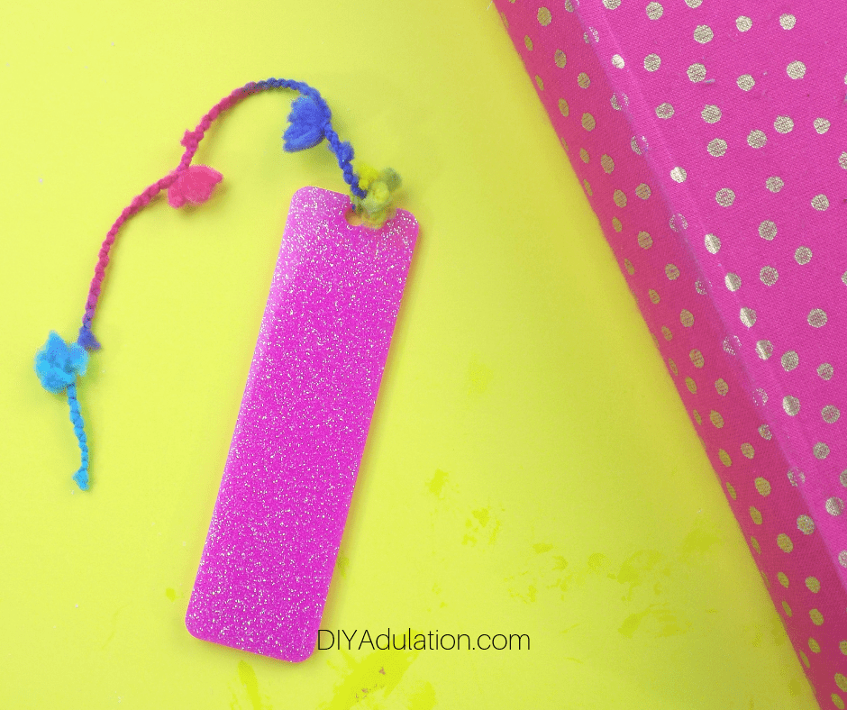 Pink Glittery DIY Bookmark with Tassel next to Journal