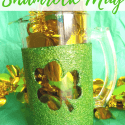 Close up of Glittery Shamrock Mug on Green Background with text overlay - DIY Glittery Shamrock Mug
