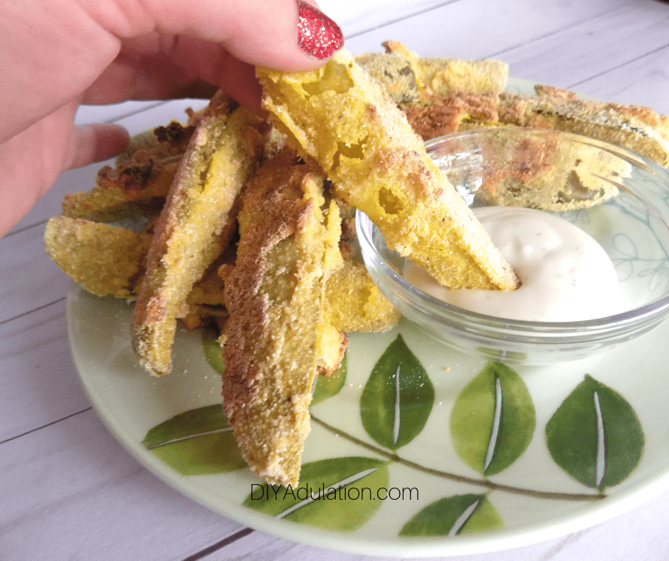 Hand Dipping Baked Pickle Spear into Ranch Dressing