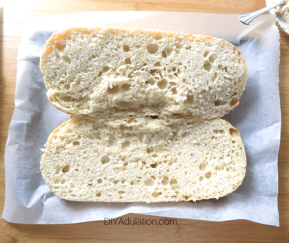 Loaf of Italian Bread Cut Open on Parchment Lined Baking Sheet
