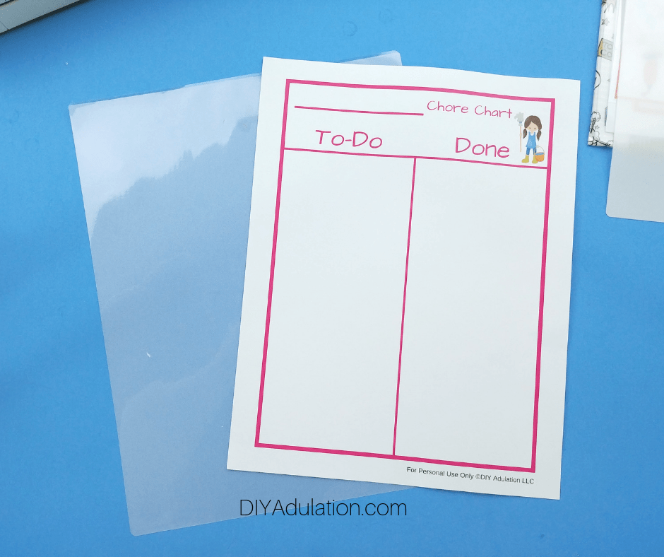 Printed Pink Chore Chart Next to Laminating Folder