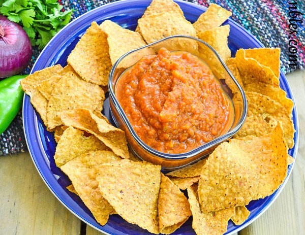 Dish of pumpkin salsa with chips circling it