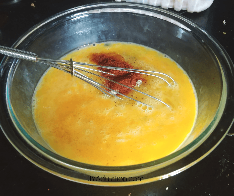 Seasoning on Whisked Eggs in Glass Mixing Bowl