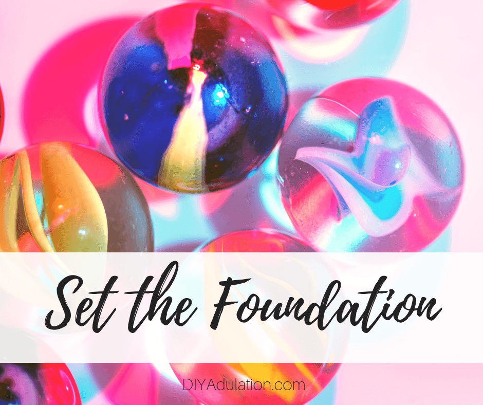 Multicolored marbles on light pink background with text overlay: Set the Foundation