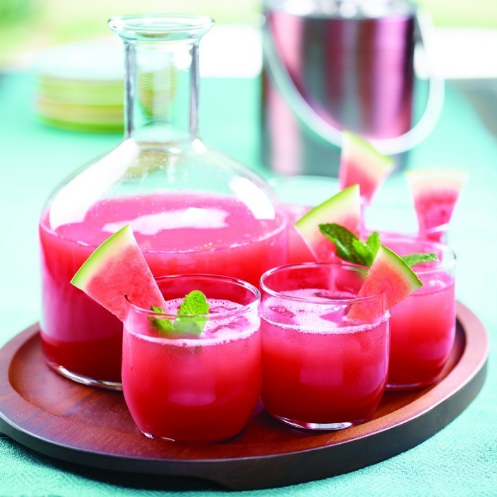 Tray of watermelon juice in glasses and pitcher