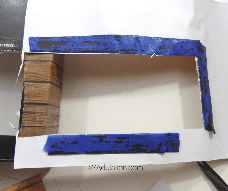 Rectangle Cut Out Inside Blue Painters Tape Attached to Backing on Tape