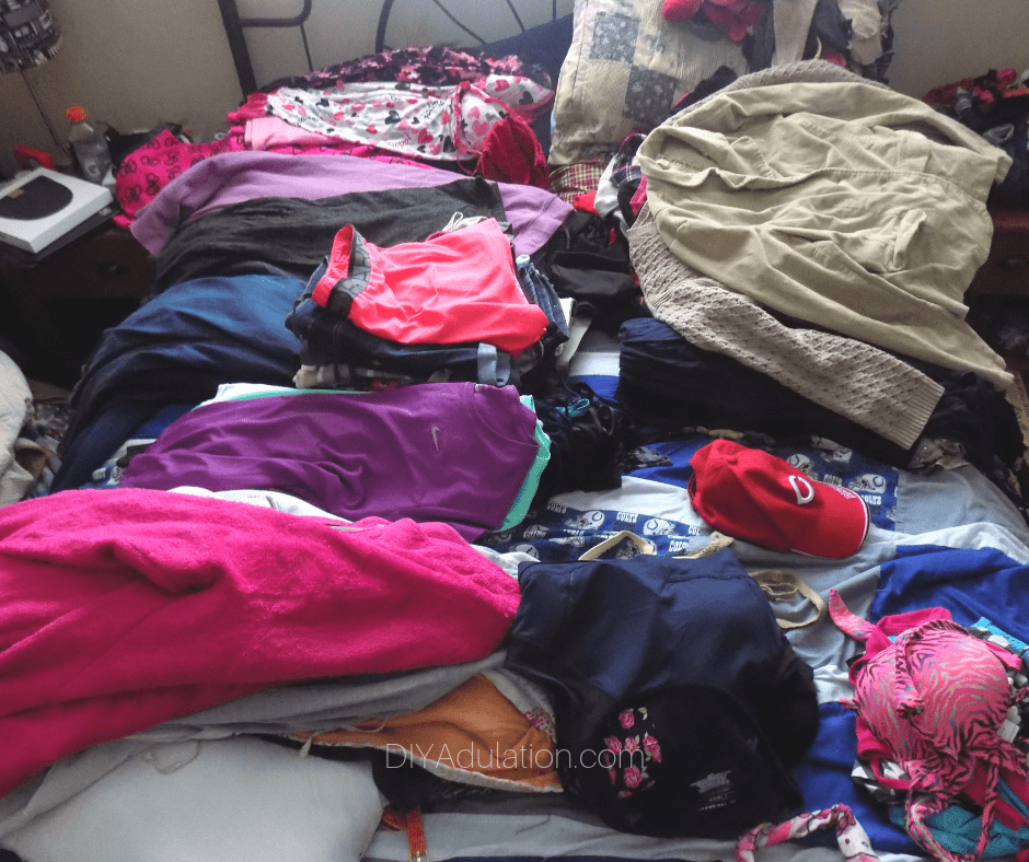Stacked Piles of Clothing on Bed