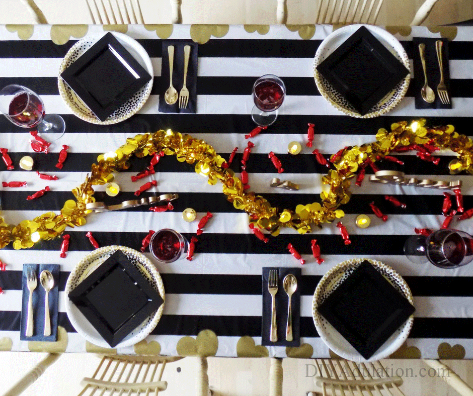 4 place settings on a black and white striped table with gold table accents