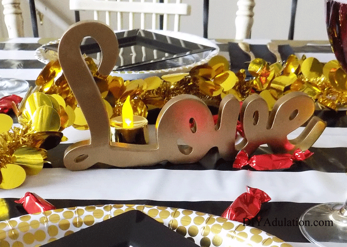 Gold word Love surrounded by gold garland and red candies